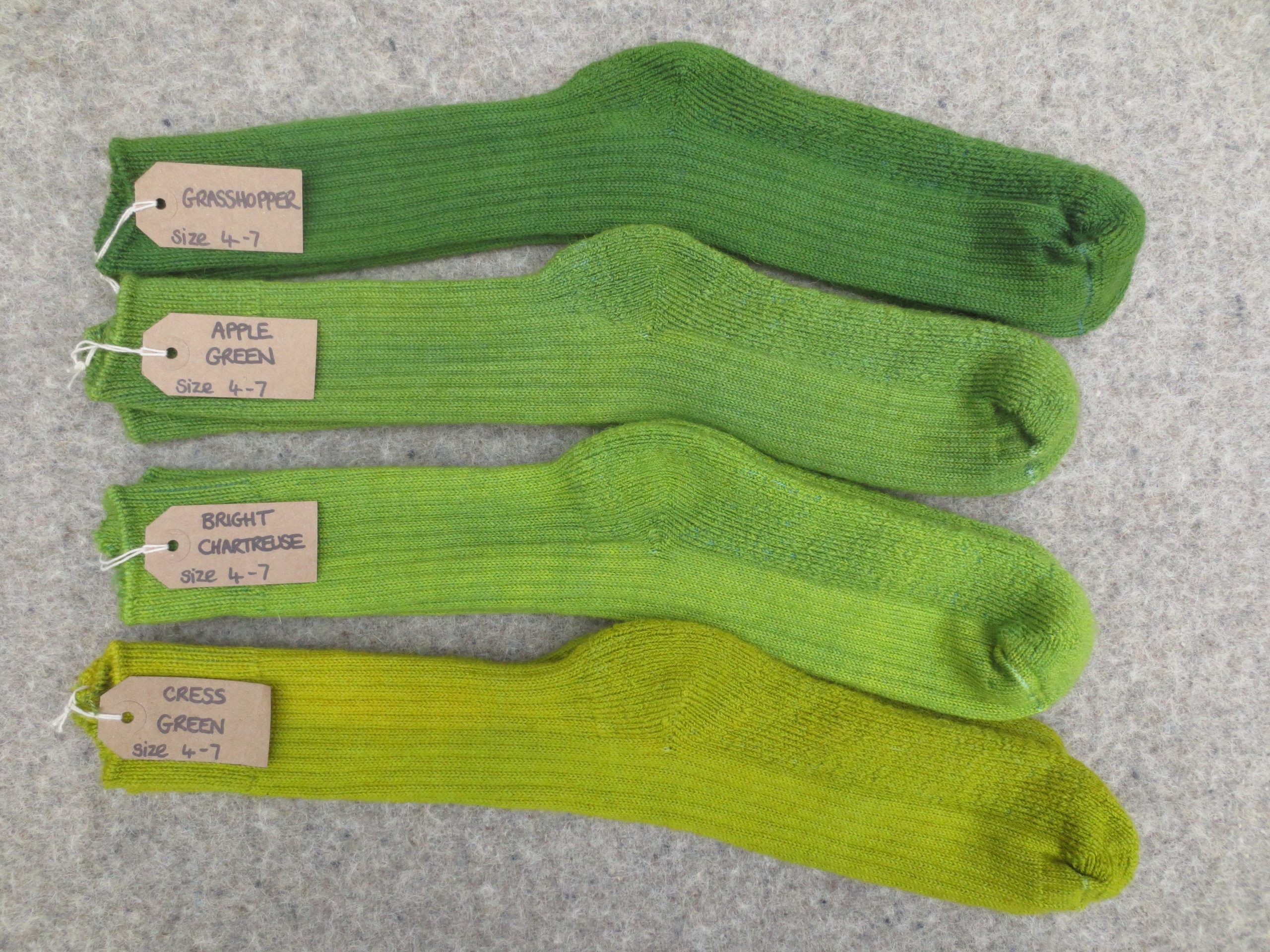 4 pairs of socks labelled Grasshopper, Apple Green, Bright Chartreuse and Cress Green
