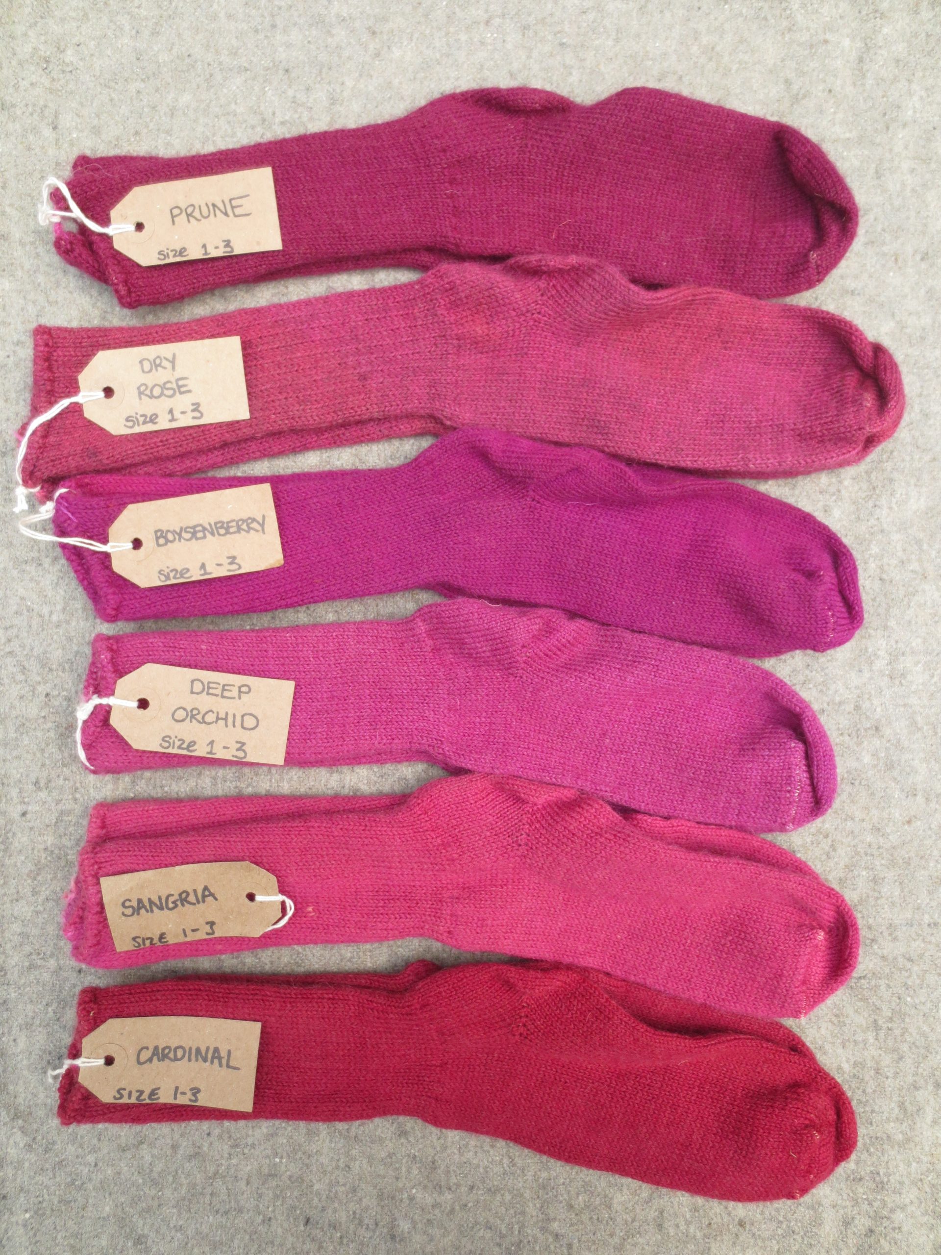 6 pairs of wool socks labelled prune, deep orchid, boysenberry, sangria, dry rose and cardinal