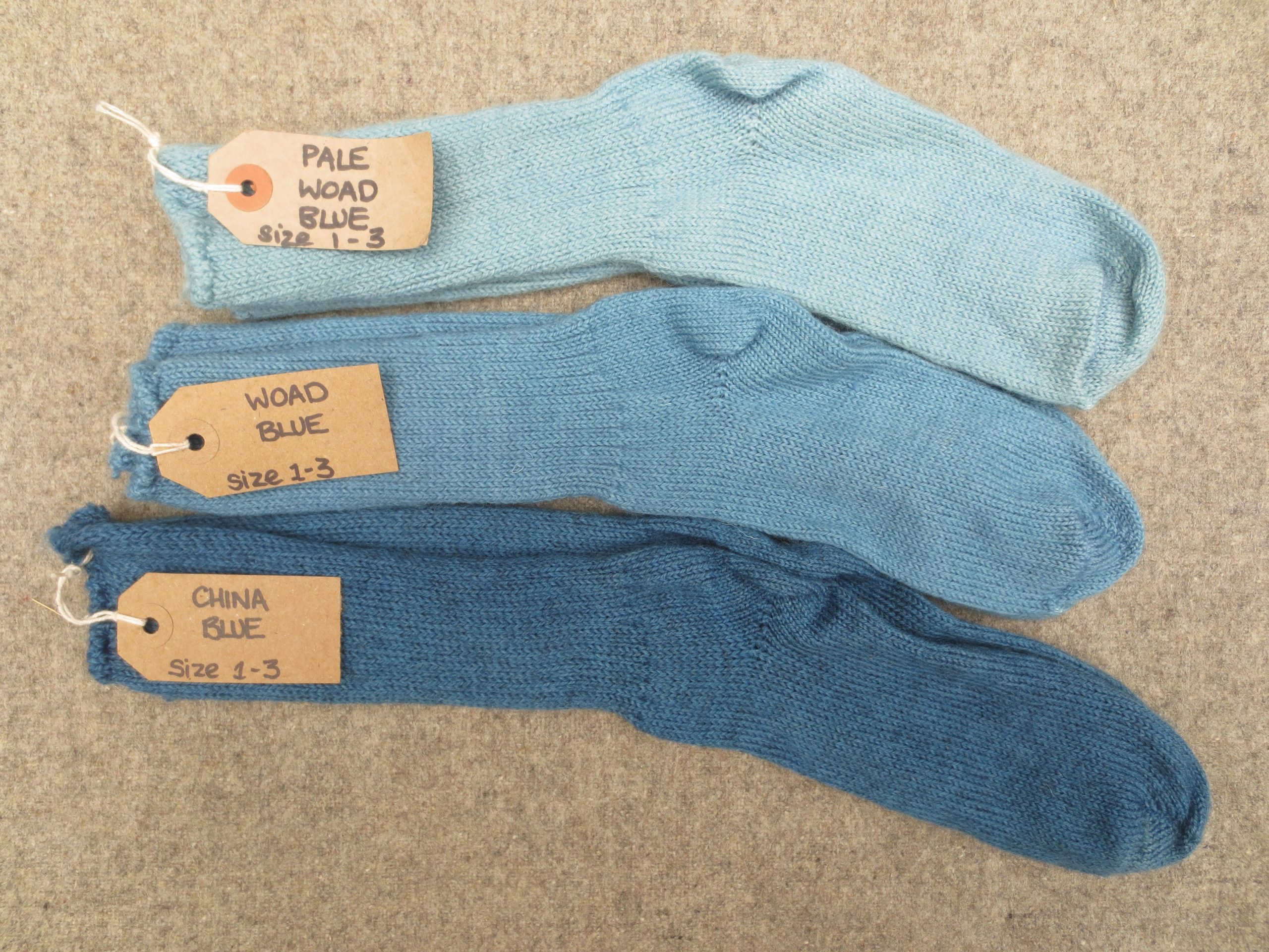3 pairs of wool socks labelled pale woad blue, woad blue, china blue