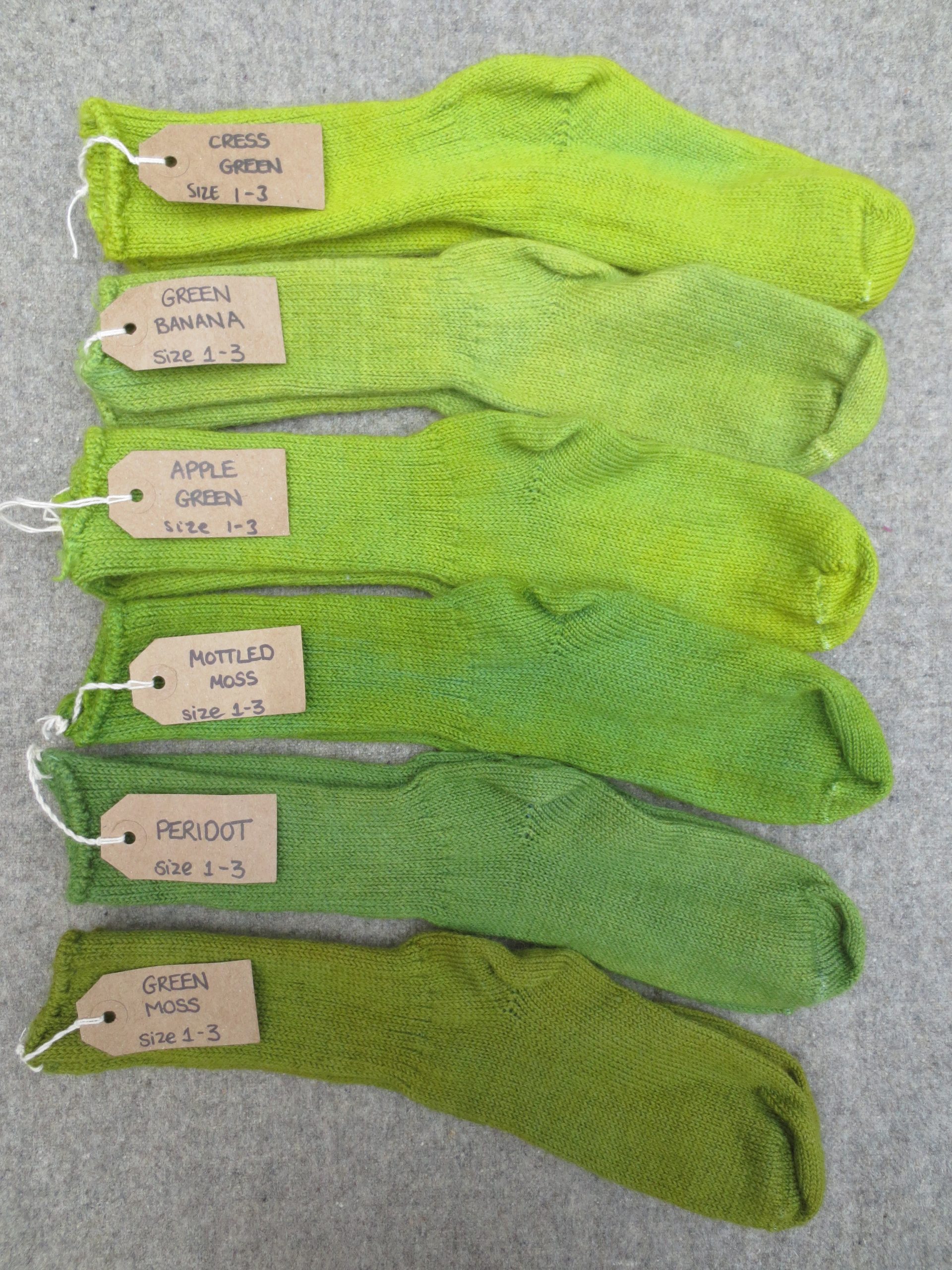 6 pairs of wool socks labelled cress green, green banana, apple green, mottled moss, peridot and green moss