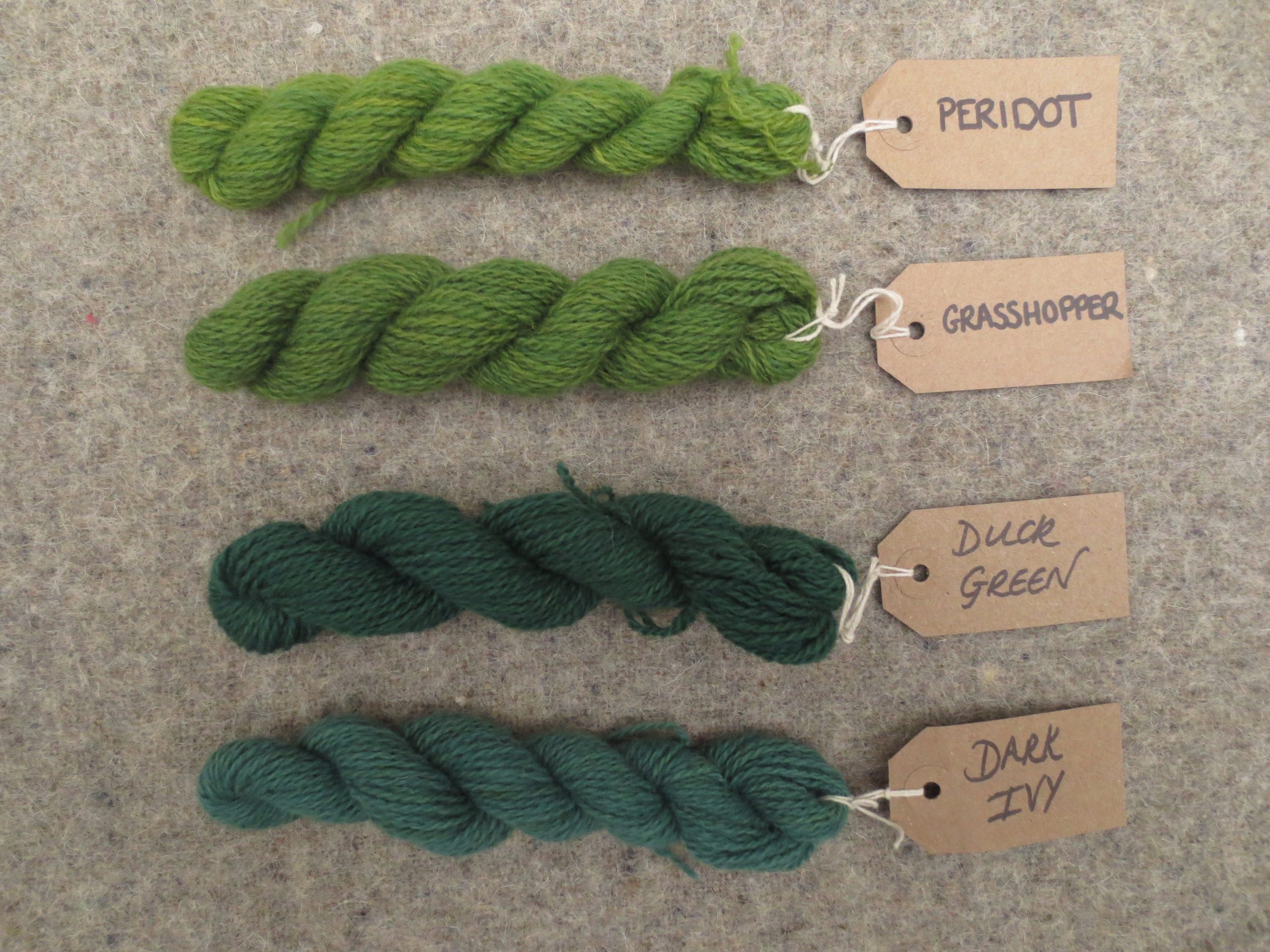 Tablet weaving wools labelled peridot, grasshopper, duck green and dark ivy