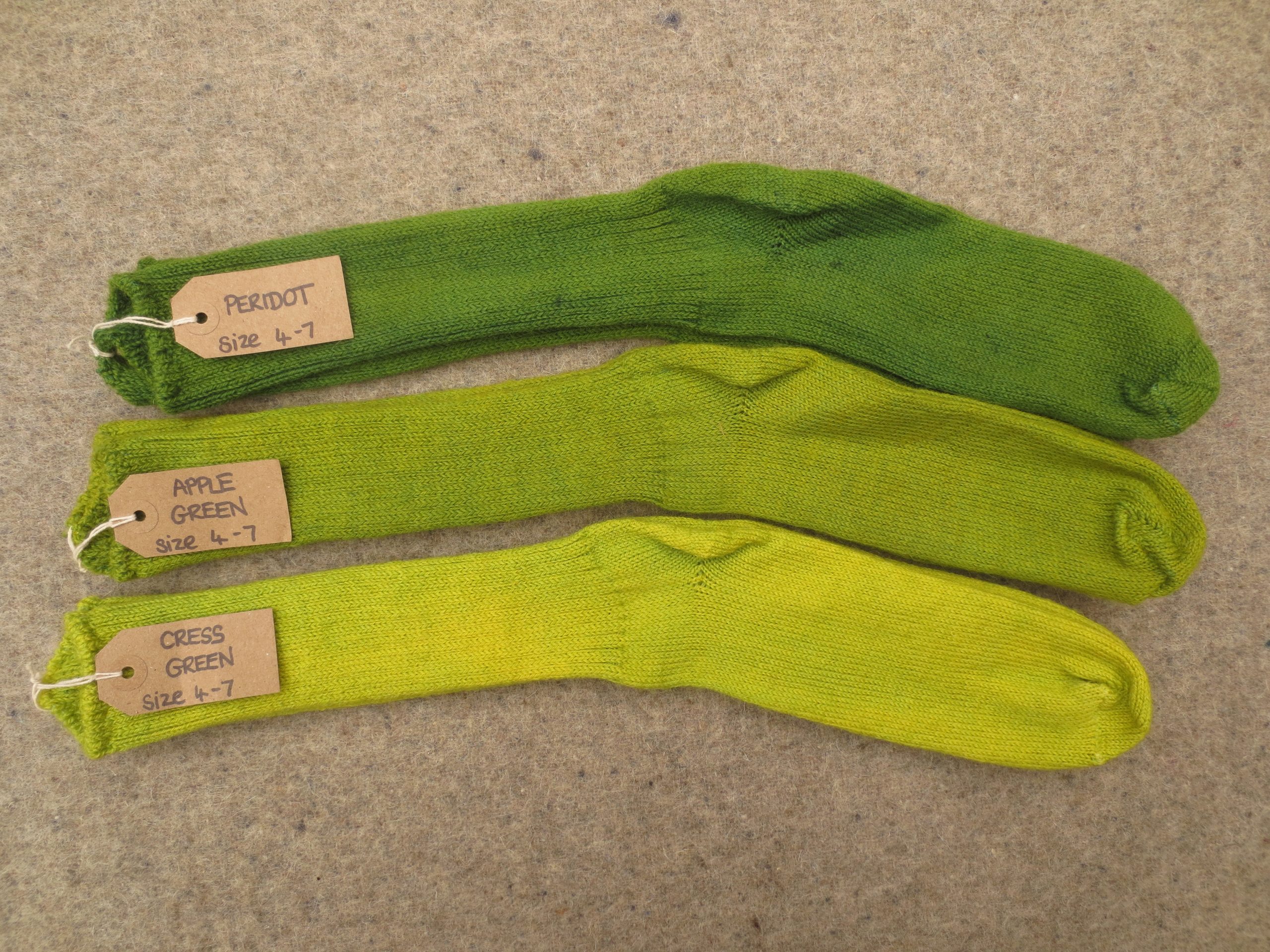 3 pairs of socks labelled Peridot, Apple Green and Cress Green