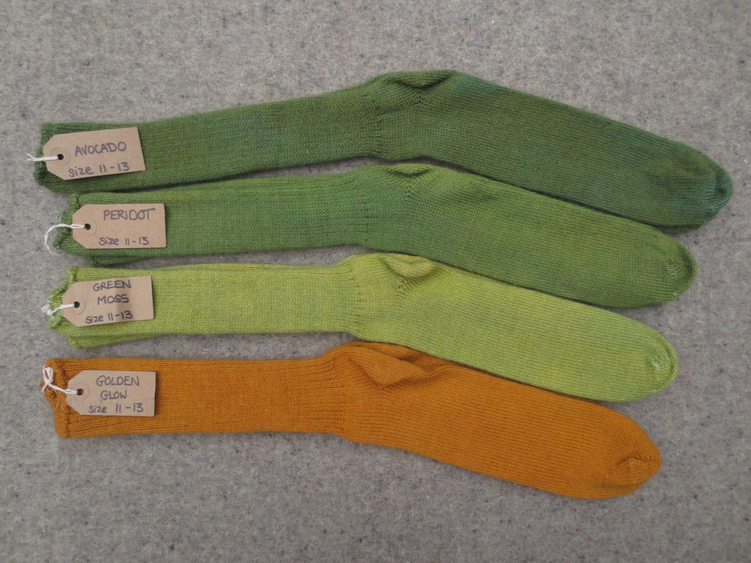 4 pairs of socks labelled Avocado, Peridot, Green Moss, Golden Glow