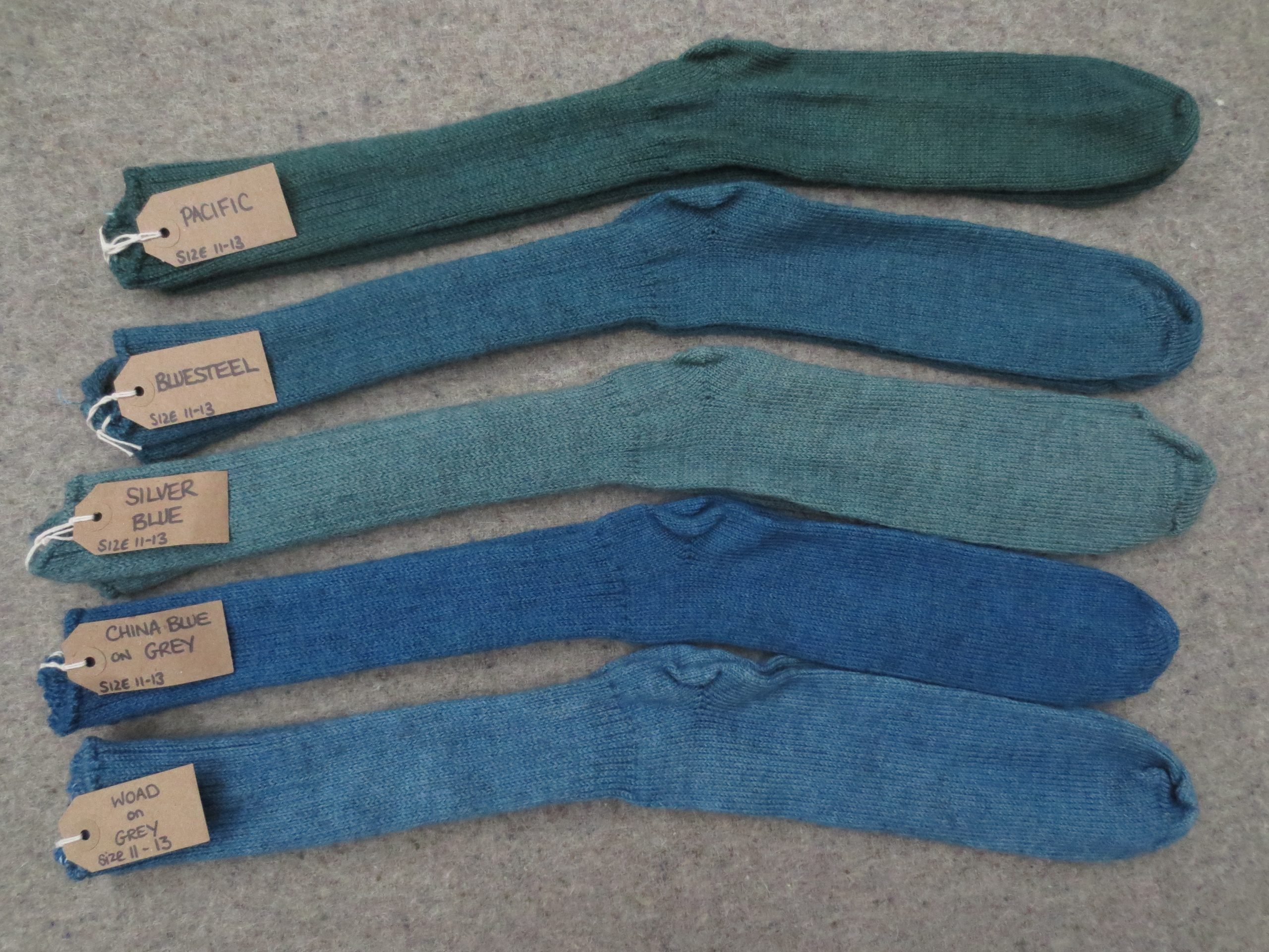 5 pairs of socks labelled Pacific, Bluesteel, Silver Blue, China Blue on Grey and Woad on Grey