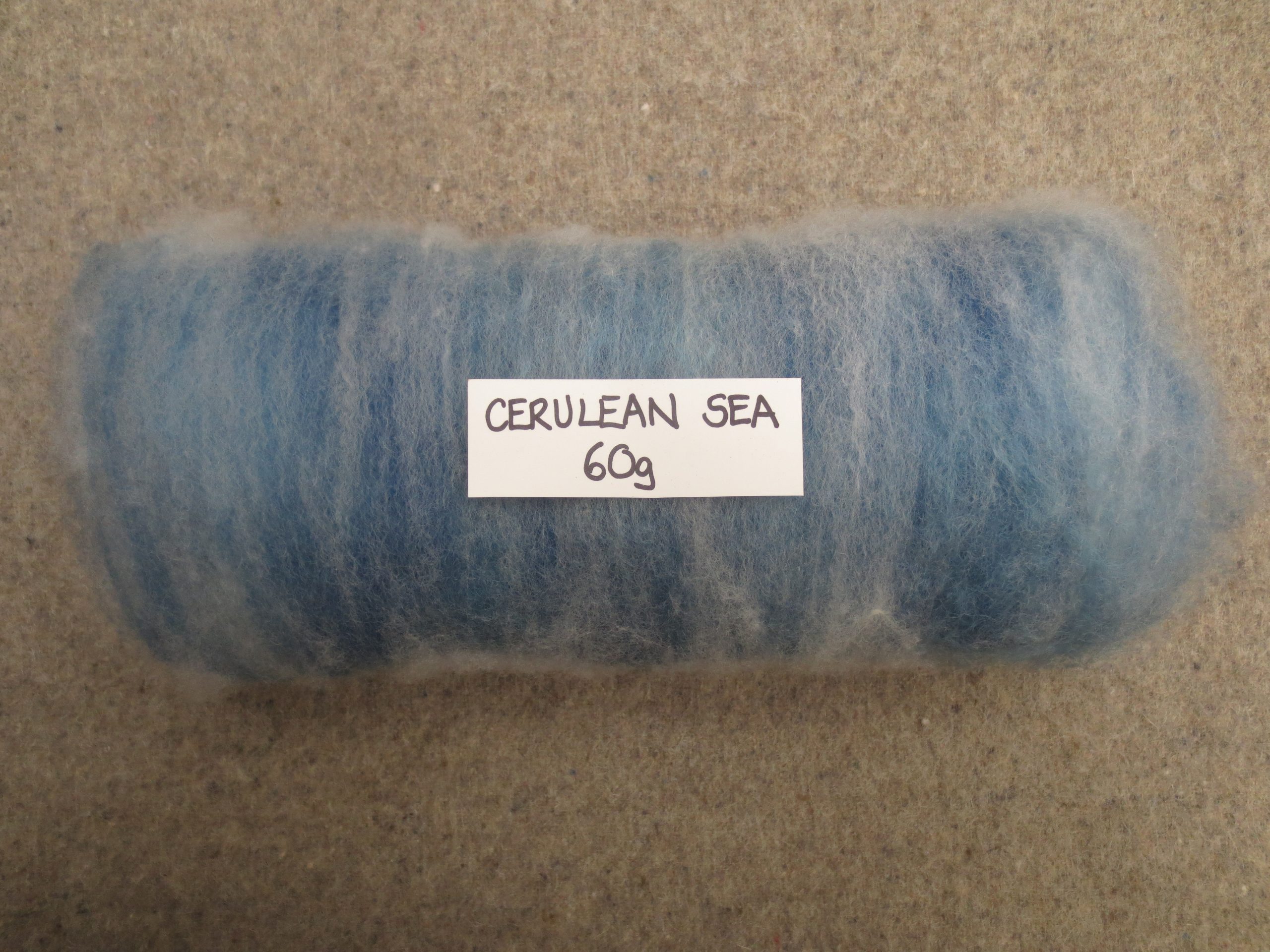 Rolled batt labelled Cerulean Sea 60g