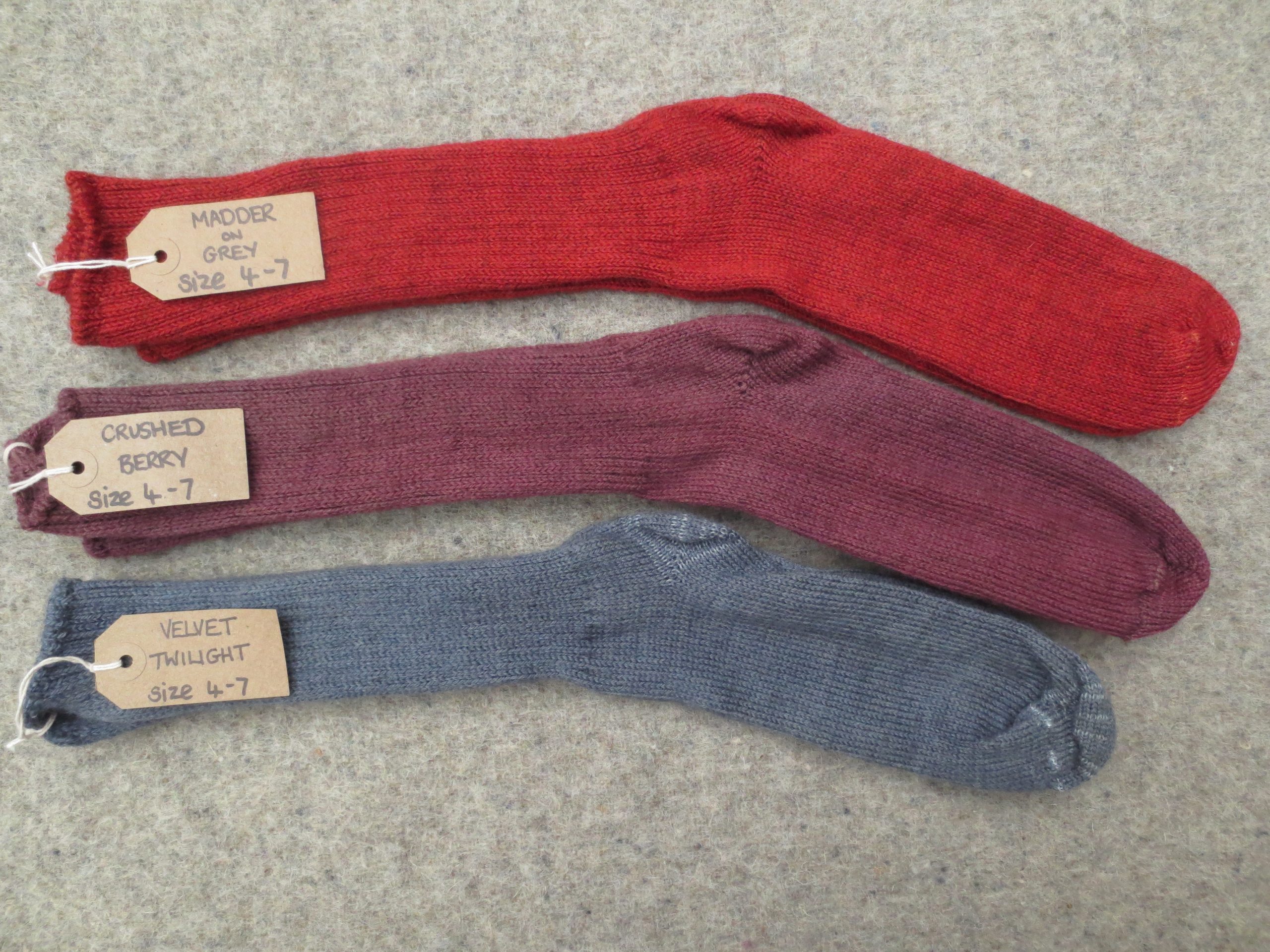 3 pairs of socks labelled Madder on Grey, Crushed Berry and Velvet Twilight