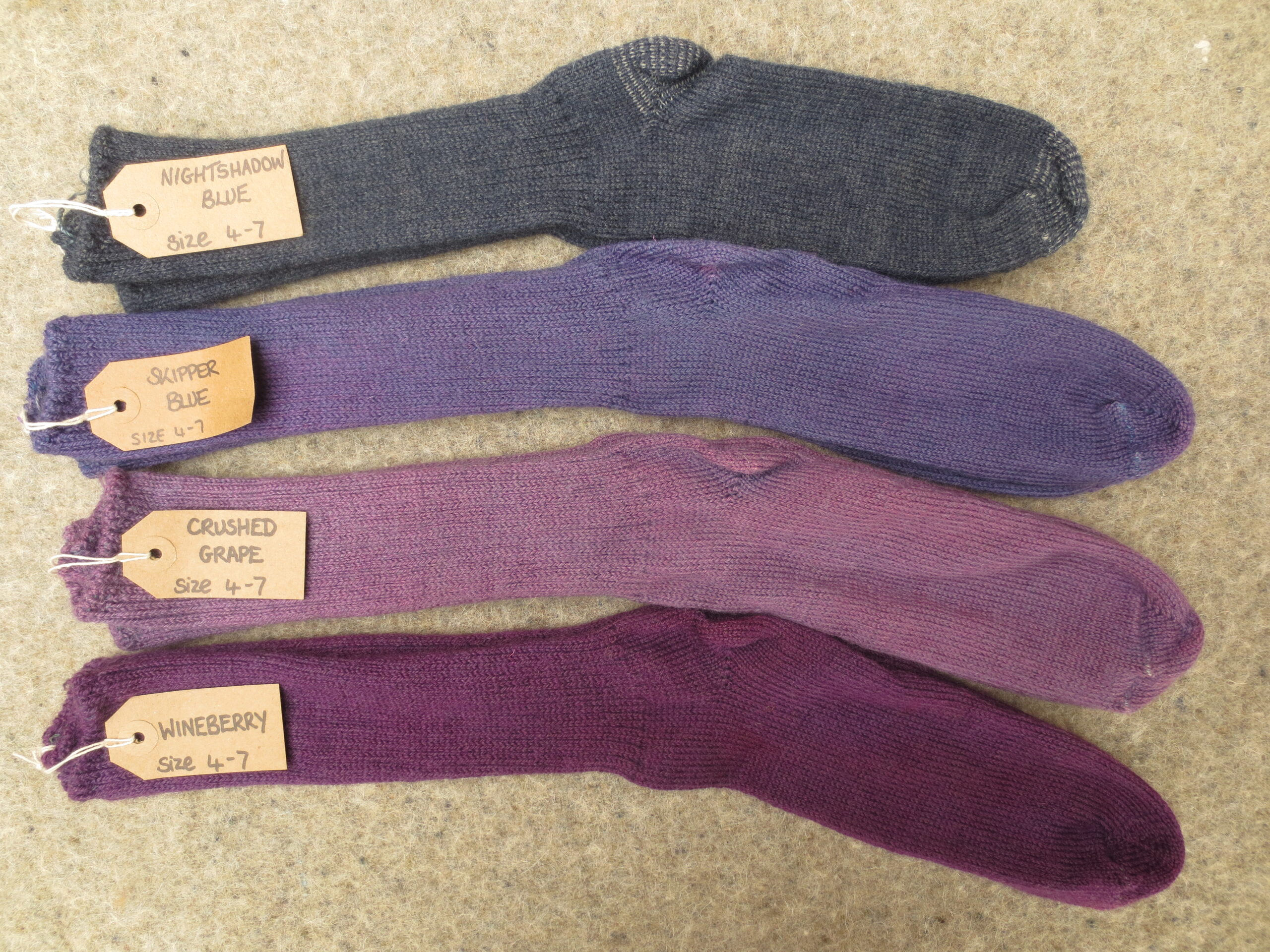 4 pairs of socks labelled Nightshadow Blue, Skipper Blue, Crushed Grape and Wineberry
