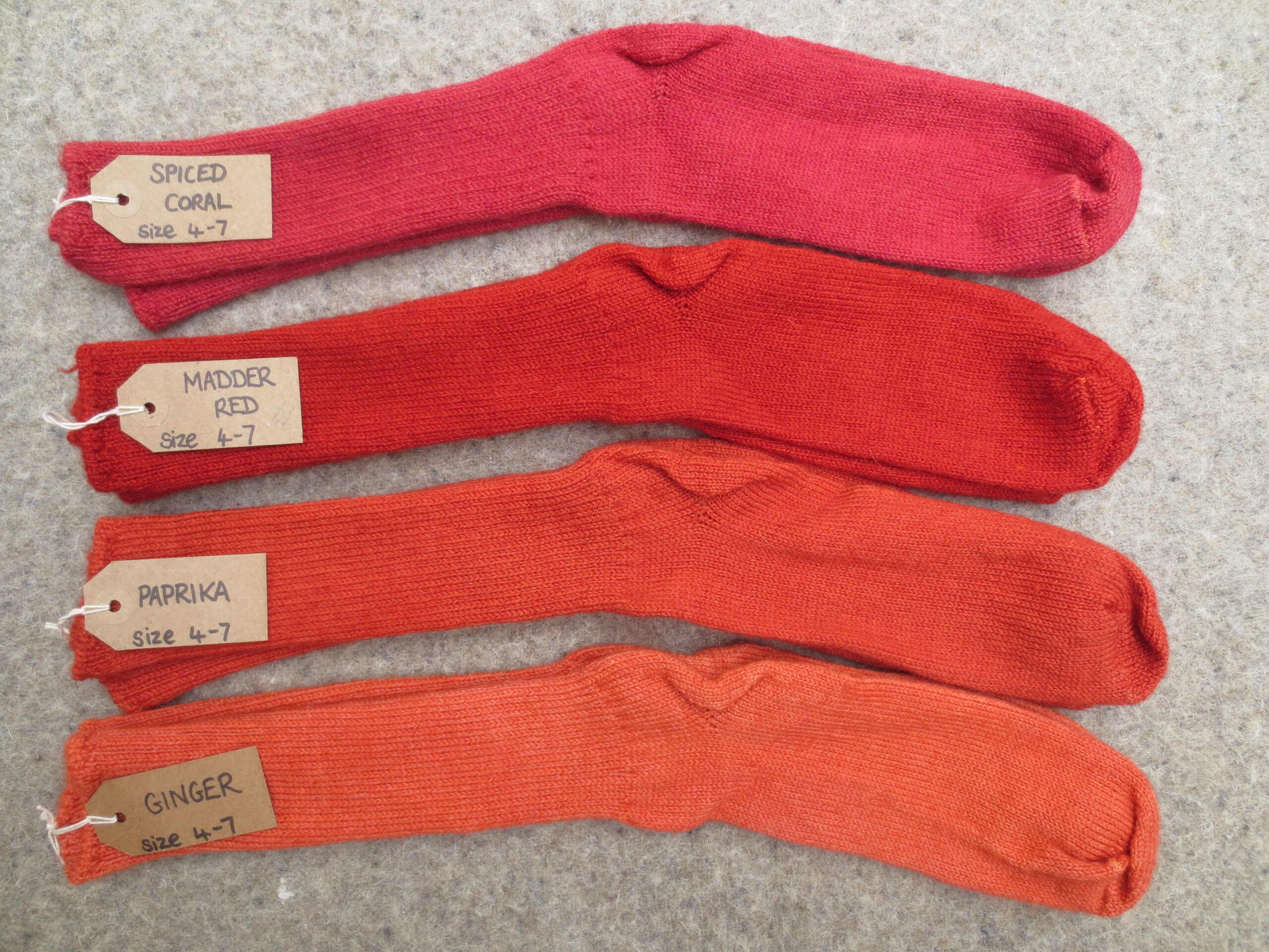 4 pairs of socks labelled Spiced Coral, Madder Red, Paprika and Ginger