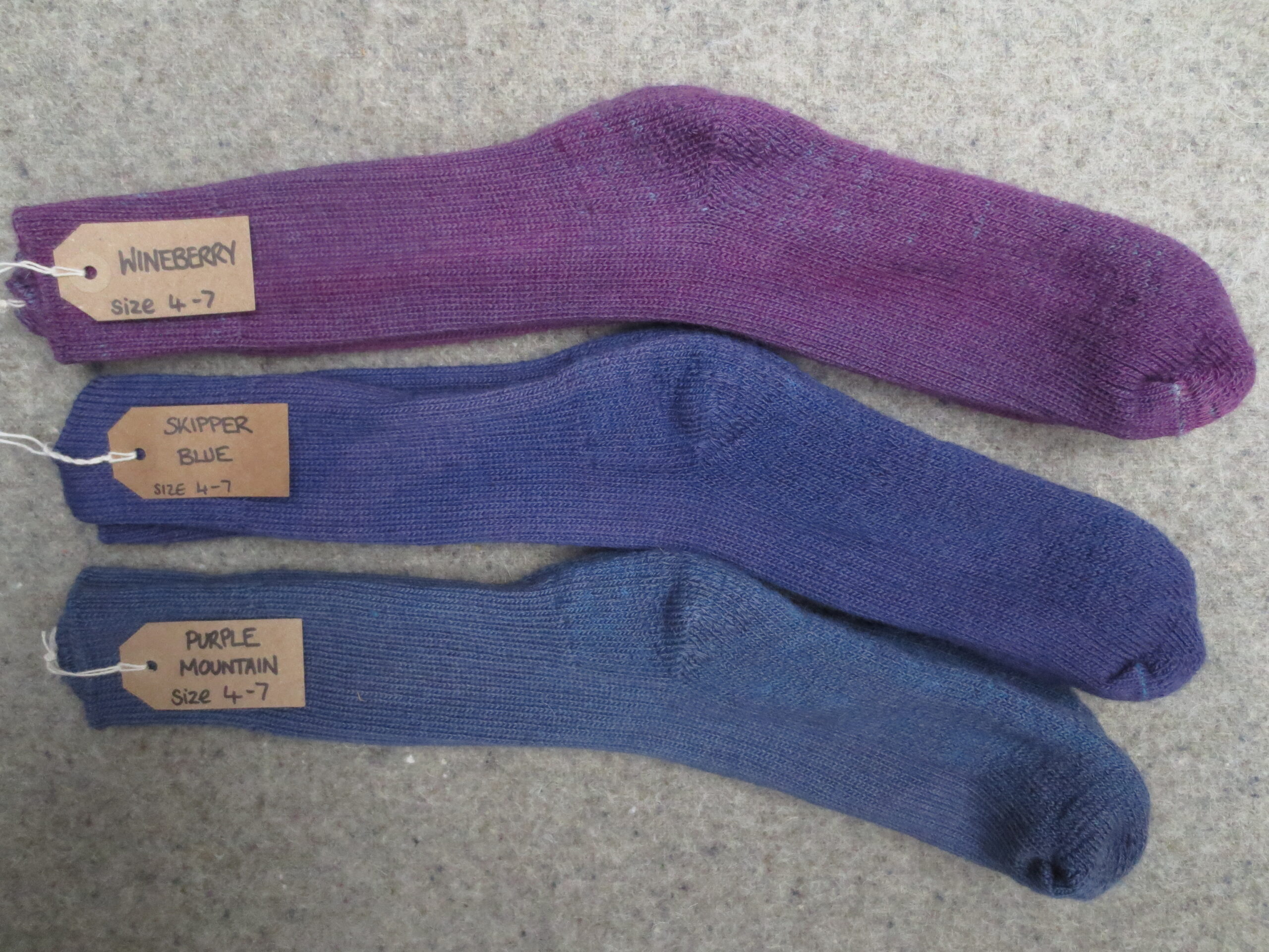 3 pairs of socksl labelled Purple Mountain, Skipper Blue and Wineberry